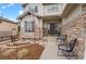 Inviting front porch with seating area and stone accents offer a welcoming entrance to the home at 24355 E Briarwood Ave, Aurora, CO 80016