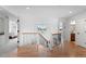 Upstairs landing with hardwood floors, black railings, and views of the modern light fixture at 24355 E Briarwood Ave, Aurora, CO 80016