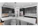 Modern kitchen boasts white countertops, black cabinetry, stainless steel appliances, and a stylish backsplash at 24355 E Briarwood Ave, Aurora, CO 80016