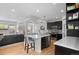 Open kitchen features a center island, stainless steel appliances, modern countertops, and black cabinetry at 24355 E Briarwood Ave, Aurora, CO 80016