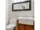 Bathroom features an antique style vanity, framed mirror, and low-flow toilet at 156 S Lindsey St, Castle Rock, CO 80104