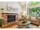 Living room featuring a traditional brick fireplace, hardwood floors, neutral furniture, and natural light at 156 S Lindsey St, Castle Rock, CO 80104