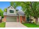 Charming two-story home with a well-manicured front yard, attached garage, and a combination of brick and siding exterior at 156 S Lindsey St, Castle Rock, CO 80104