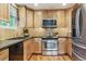 Well-lit kitchen featuring stainless steel appliances, light wood cabinetry, and dark countertops at 156 S Lindsey St, Castle Rock, CO 80104