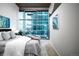 Light-filled main bedroom with stylish furnishings, expansive glass window and serene artwork at 1700 Bassett St # 1119, Denver, CO 80202