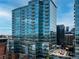 Modern high-rise building featuring extensive glass balconies and sleek design against a blue sky at 1700 Bassett St # 1119, Denver, CO 80202