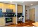 Modern kitchen with stainless appliances, a built-in desk, and black backsplash at 1700 Bassett St # 1119, Denver, CO 80202