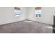 Bright bedroom with two windows offering neighborhood views and neutral-colored carpet at 6214 Long Branch Dr, Parker, CO 80134