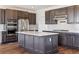 Bright kitchen with stainless appliances, a center island with a quartz countertop, and dark wood-tone cabinetry at 6214 Long Branch Dr, Parker, CO 80134