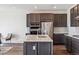 Kitchen with stainless steel appliances, dark wood cabinets, large island, and modern white backsplash at 6214 Long Branch Dr, Parker, CO 80134