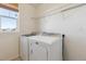 Functional laundry room with modern washer and dryer, plus convenient shelving for storage at 6214 Long Branch Dr, Parker, CO 80134