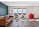 Living room featuring wood floors, comfortable seating, bright light from windows with views, and stylish decor at 6214 Long Branch Dr, Parker, CO 80134