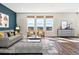 Bright living room features modern furnishings, hardwood floors, and multiple windows with scenic views at 6214 Long Branch Dr, Parker, CO 80134