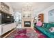 Living room with green couch, fireplace and large TV at 45 Jackson St # A, Denver, CO 80206