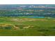 Sweeping aerial of the landscape showcasing the skyline and lakes amid green fields and trees at 8932 Eastridge Rd, Golden, CO 80403