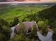 An aerial view displays a luxury home surrounded by lush greenery and stunning mountain landscapes at 8932 Eastridge Rd, Golden, CO 80403