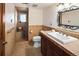 A traditionally designed bathroom with earth-toned tiles, vanity, and a step-in shower with glass door at 8932 Eastridge Rd, Golden, CO 80403