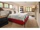 Bright bedroom with a decorative black metal frame bed and a beautiful view from two large windows at 8932 Eastridge Rd, Golden, CO 80403