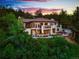 A luxury home exterior with a manicured lawn, an elevated terrace, and surrounded by lush trees at 8932 Eastridge Rd, Golden, CO 80403