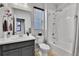 Well-lit bathroom featuring a vanity with sink, toilet, and bathtub-shower combo with white tile surround at 27853 E 8Th Ave, Aurora, CO 80018