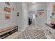 Inviting hallway with decorative wall art, bench with shoe storage, and an open entrance to the laundry room at 27853 E 8Th Ave, Aurora, CO 80018