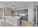 Modern kitchen featuring gray cabinets, a large island with seating, and stainless steel appliances at 27853 E 8Th Ave, Aurora, CO 80018