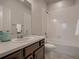 Well-lit bathroom featuring a vanity, sink, toilet, and a shower-tub combo with tiled walls at 6894 E 133Rd Pl, Thornton, CO 80602