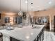 Open kitchen with a large island, pendant lighting, and seamless flow into the living area at 6894 E 133Rd Pl, Thornton, CO 80602
