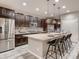 Spacious kitchen with dark cabinets, stainless steel appliances, and a large center island with seating at 6894 E 133Rd Pl, Thornton, CO 80602