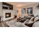 Cozy living room features a fireplace, plush seating, a patterned rug, and large windows at 6894 E 133Rd Pl, Thornton, CO 80602
