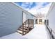 Back entrance with wooden stairs, a light blue house with siding, and a shed under a partly cloudy sky at 2115 W 90Th Ave, Federal Heights, CO 80260