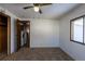 View of the bedroom and connecting Laundry Room with neutral carpet, white paneled walls, and a ceiling fan at 2115 W 90Th Ave, Federal Heights, CO 80260