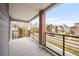 Spacious covered balcony with brick column overlooking the neighborhood street at 3928 N Vrain St, Denver, CO 80212