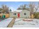 Charming home with a red front door, snowy yard, and quaint seating area at 1125 Newark St, Aurora, CO 80010