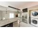 Open concept kitchen with stainless steel appliances, island, and laundry area at 1125 Newark St, Aurora, CO 80010