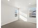 A sunlit bedroom with neutral carpet and two windows providing natural light at 259 E 4Th St, Berthoud, CO 80513