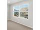 This bedroom has a carpeted floor and a window that looks out to another home at 259 E 4Th St, Berthoud, CO 80513