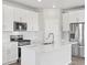 Well-lit kitchen featuring stainless steel appliances, white cabinets, backsplash, and a large island at 259 E 4Th St, Berthoud, CO 80513