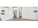Modern kitchen features white cabinets, stainless steel appliances, a center island, and hardwood floors, showcasing a clean design at 259 E 4Th St, Berthoud, CO 80513