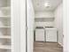 Convenient laundry room with modern washer and dryer, shelving, and wood-look floors at 259 E 4Th St, Berthoud, CO 80513