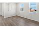 Bright living room featuring wood floors and ample natural light from two large windows at 259 E 4Th St, Berthoud, CO 80513