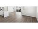 Open concept living space features hardwood floors, seamlessly connecting the living room to the modern kitchen at 259 E 4Th St, Berthoud, CO 80513