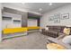 Finished basement area featuring a wet bar with grey cabinets and a comfortable seating area at 1813 W 67Th Ave, Denver, CO 80221