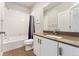 This full bathroom features modern fixtures, a shower and tub, and sleek white cabinets at 1813 W 67Th Ave, Denver, CO 80221