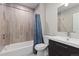 Bathroom featuring a shower and tub combination and wooden textured tile walls at 1813 W 67Th Ave, Denver, CO 80221