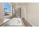 Clean bathroom features soaking tub, shower, and a large window bringing in natural light at 1813 W 67Th Ave, Denver, CO 80221