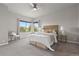 Bright bedroom featuring neutral tones, a ceiling fan, and large window with peaceful outdoor views at 1813 W 67Th Ave, Denver, CO 80221