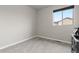 A minimalist bedroom featuring neutral tones, a large window, and plush carpeting for a cozy ambiance at 1813 W 67Th Ave, Denver, CO 80221