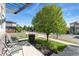 Charming front yard features a mature tree, green lawn, and inviting seating area on the porch at 1813 W 67Th Ave, Denver, CO 80221