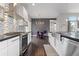 Contemporary kitchen with stainless steel appliances, mosaic backsplash, and adjacent dining area at 1813 W 67Th Ave, Denver, CO 80221